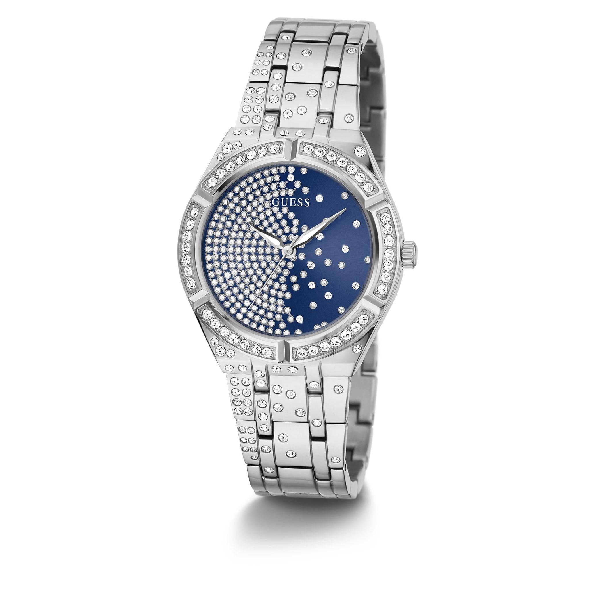 The Guess GW0312L1 Ladies Silver Tone Afterglow Stone Set Bracelet Watch features a blue dial, crystal-accented bezel and dial, and a metal link band with a crystal-set bracelet for added elegance.