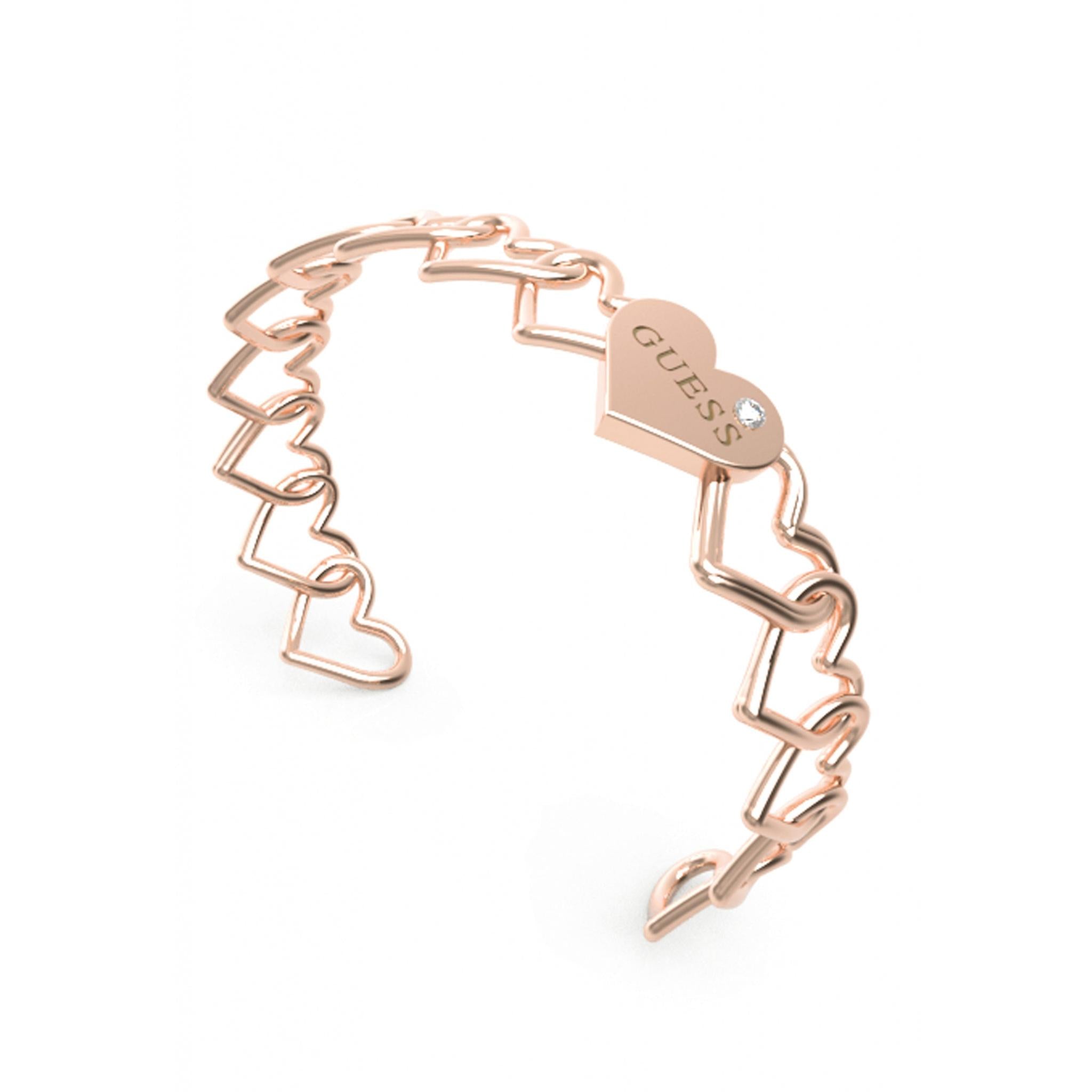 The GUESS JEWELLERY Ladies Rose Gold Tone Heart To Heart Bangle (UBB01086RgL) features heart-shaped links, a "GUESS" engraved heart charm, and a decorative gem—an elegant rose gold addition to your collection.