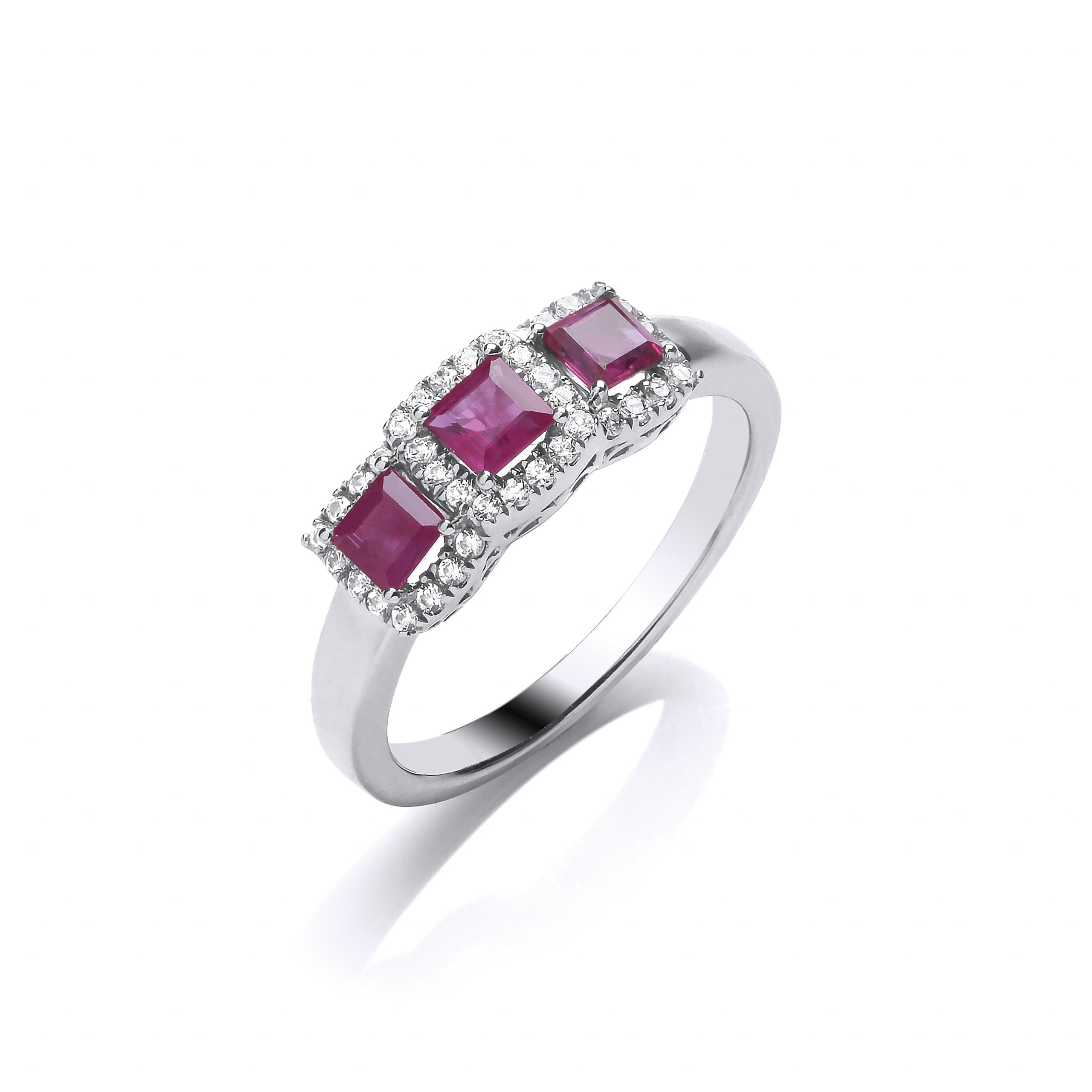 The 9ct White Gold Diamond and Ruby Trilogy Ring 0.19ct features three princess cut rubies, each surrounded by sparkling diamonds, all set in a polished white gold band.