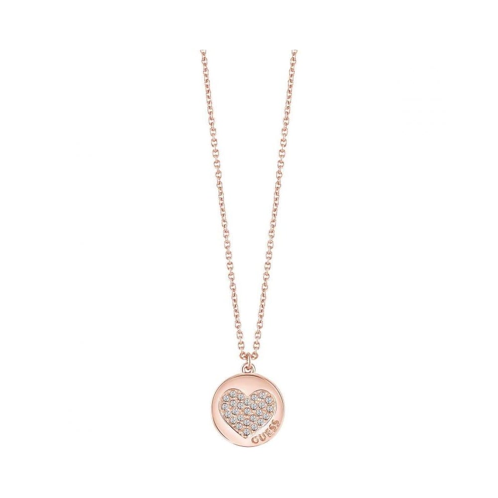 The GUESS JEWELLERY Devotion Necklace UBN82052 features a rose gold-tone heart-shaped pendant with crystal inlays and "GUESS" engraved at the bottom.