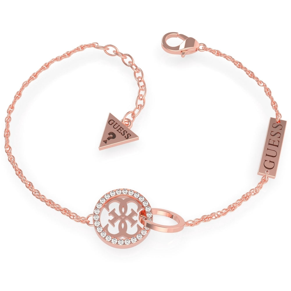 The Guess Equilibre Rose Gold Plated Logo Bracelet UBB79079-L features a circular Swarovski crystal charm, a "GUESS" bar tag, and a triangular logo tag for signature style.