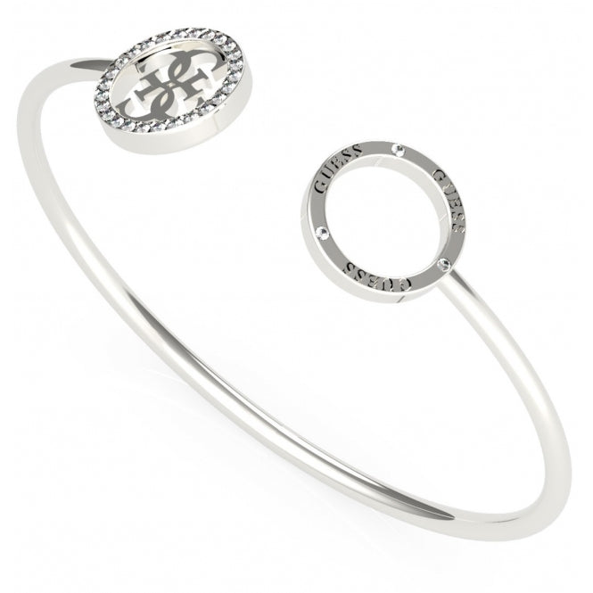 The Guess UBB79080-L Women's Silver Tone Equilibre bangle features an open oval design with the 4G logo and a sparkling oval accent framed by clear stones.