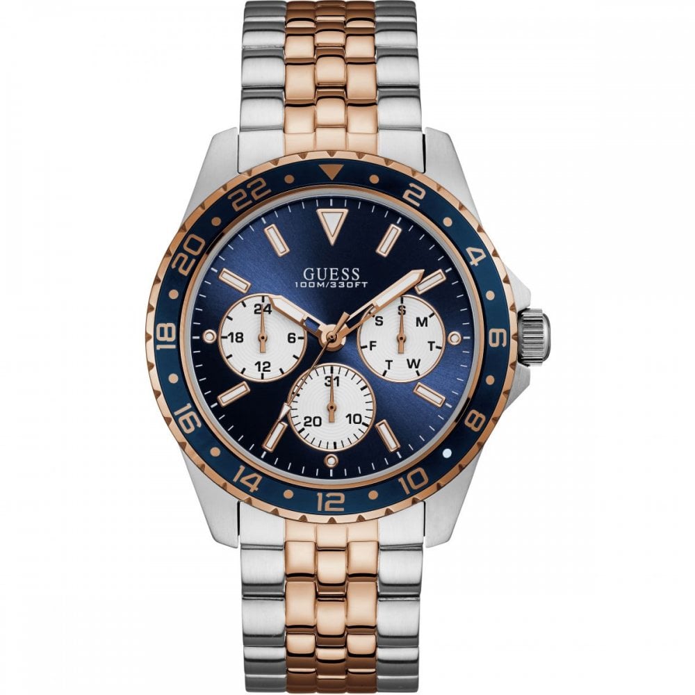 The Guess W1107G3 Odyssey Men's Two Tone Rose Gold Bracelet Watch has a silver and rose gold band, blue bezel and dial, three multifunction subdials, and silver hour markers.