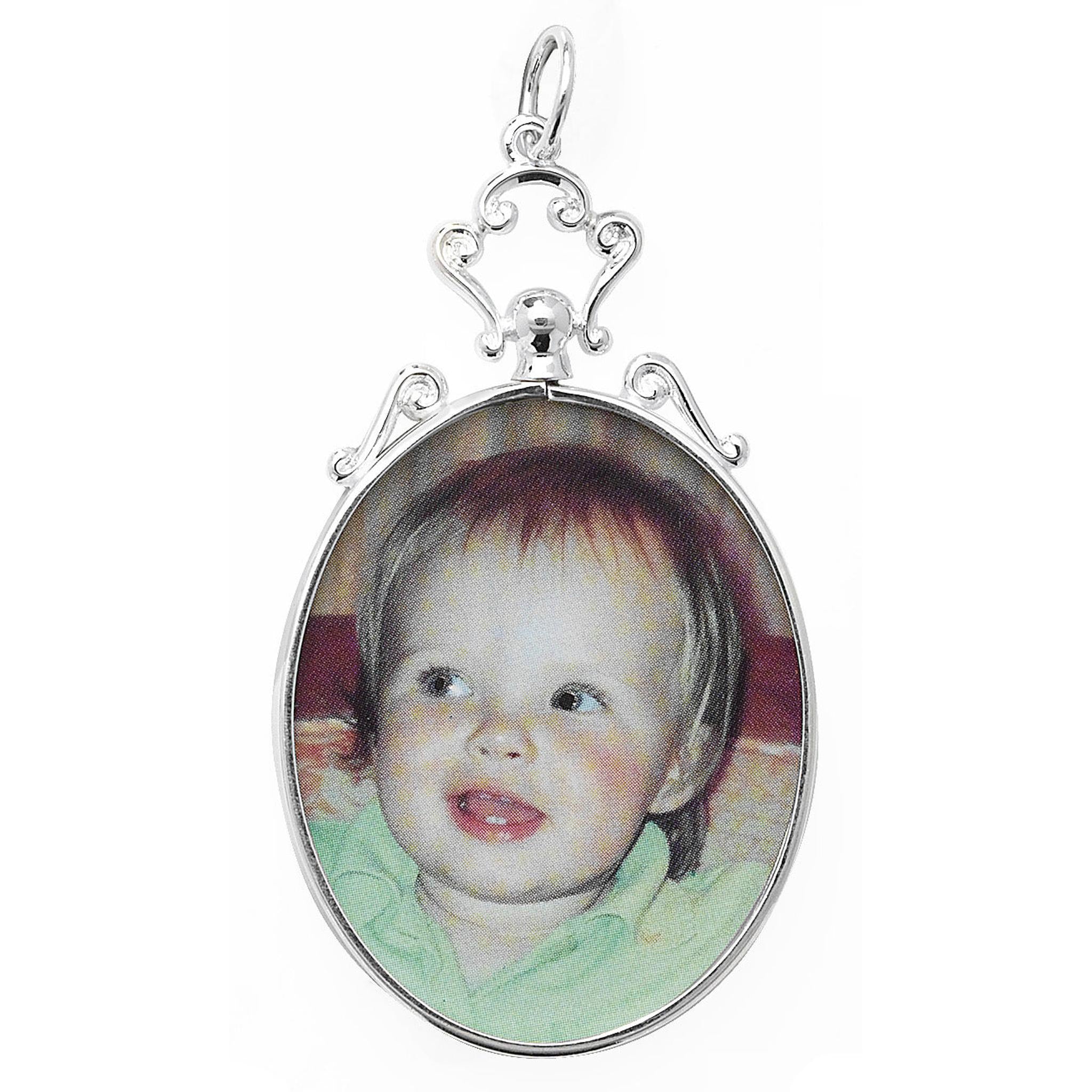 STERLING SILVER SCROLL TOP PHOTO PENDANT, 29mm x 55mm and 8.2g, features an oval frame with a photo of a smiling, light-haired child in a light green shirt.
