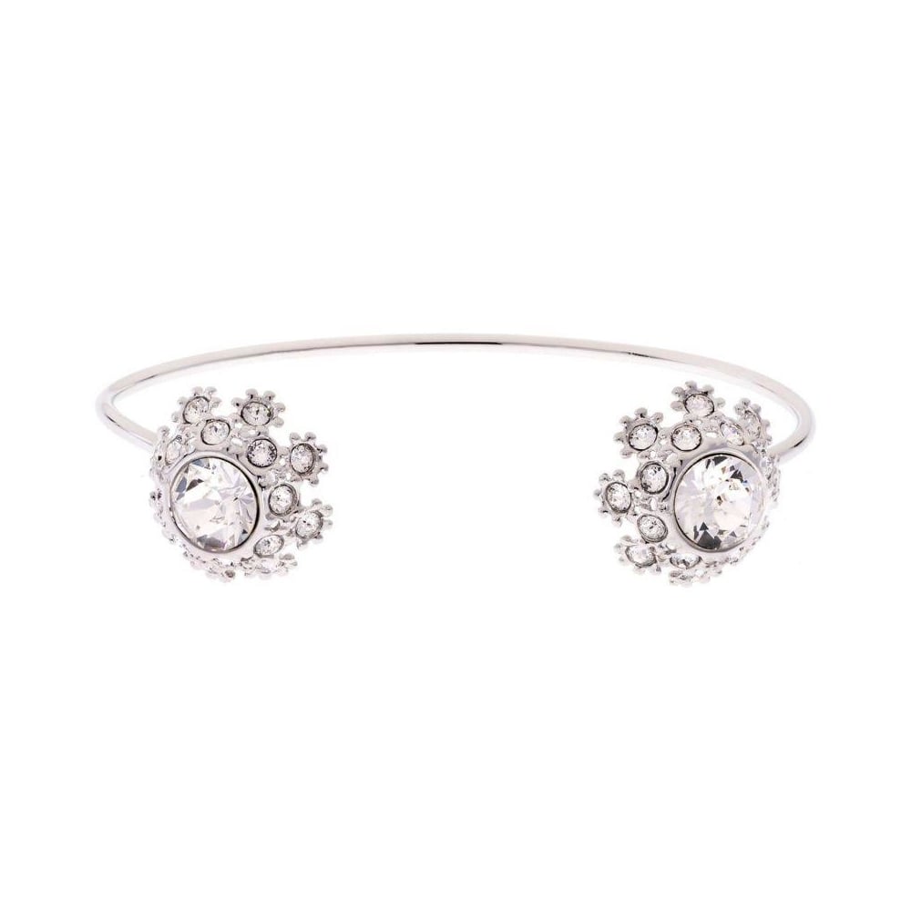 The TED BAKER Seniie Crystal Daisy Lace Cuff Bangle (TBJ1582-01-02) is silver-plated, featuring two large clear gemstones on each end, accented by small stones in a daisy-inspired floral design.