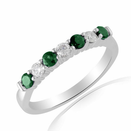 This 9ct white gold half eternity ring showcases seven alternating diamonds and emeralds, totaling 0.11ct, in a sparkling row.