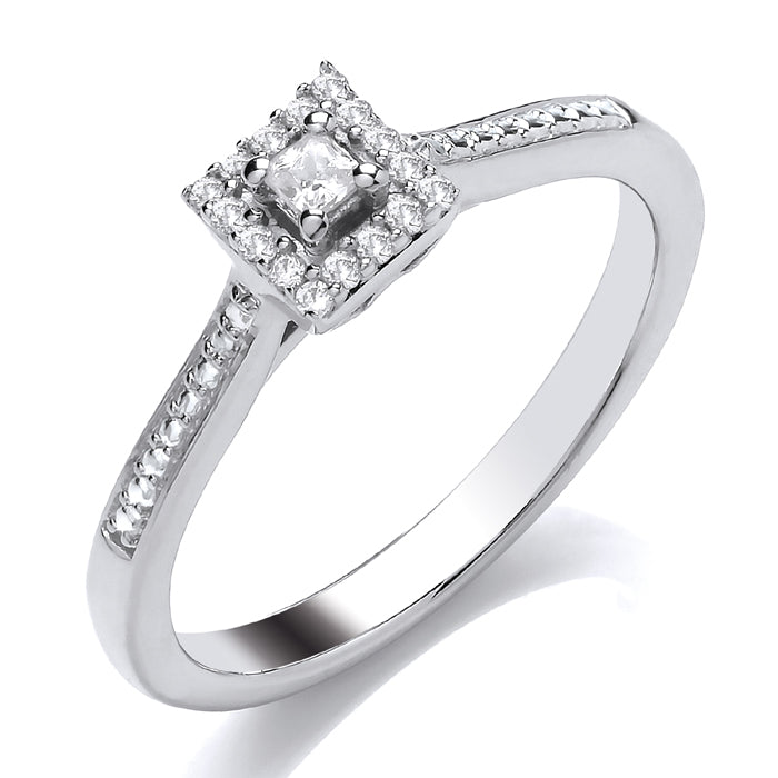 The 9ct White Gold Princess Cut Ring 0.10ct features a dazzling princess cut diamond set in a square halo, with additional sparkling diamonds along the band for extra brilliance.