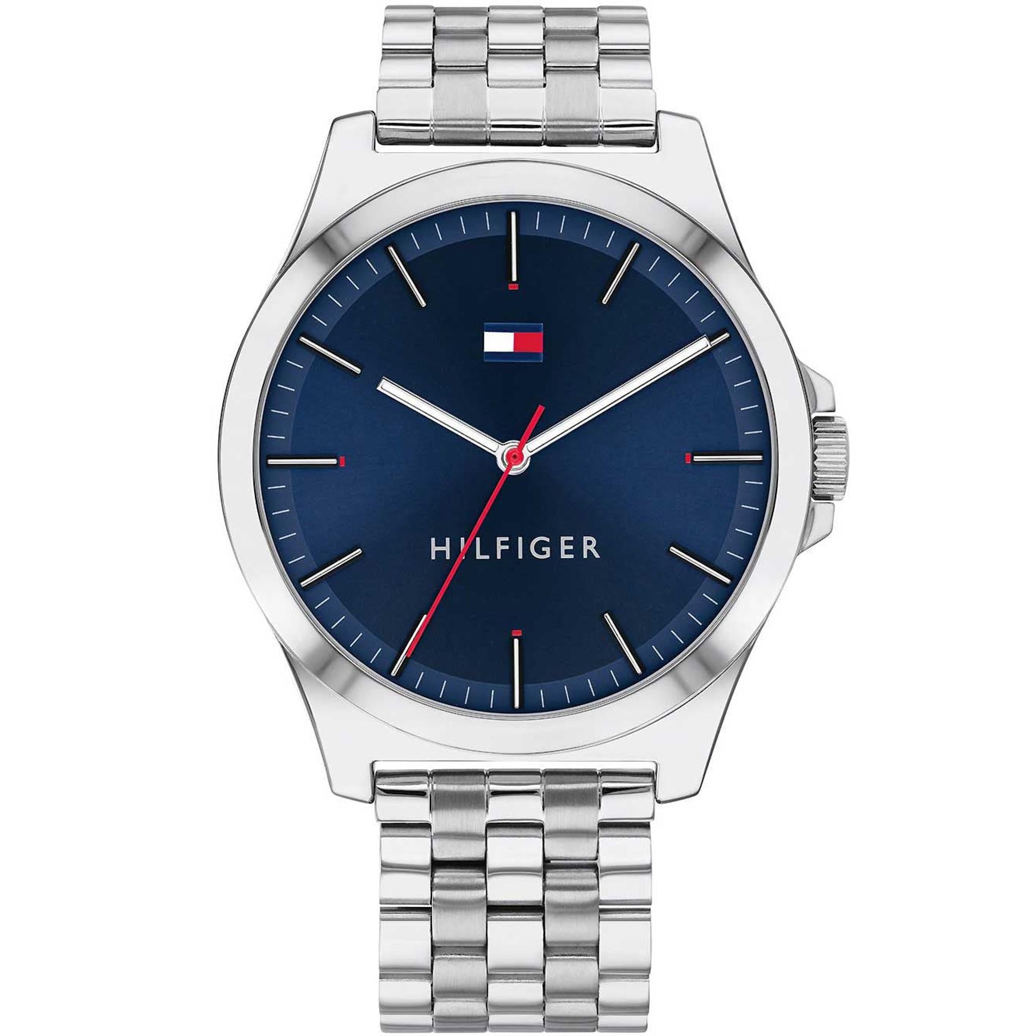 The Tommy Hilfiger 1791713 Barclay men's watch features a blue dial with minimal markers, Hilfiger logo below 12 o’clock, and a sleek silver-tone stainless steel bracelet. Water resistant to 3ATM.