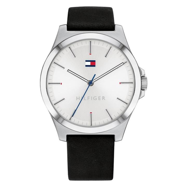 The Tommy Hilfiger Barclay Gents Stainless Steel Black Leather Strap Watch 1791716 features a silver case, white dial with minimal markers, black leather strap, and iconic logo at 12 o’clock.
