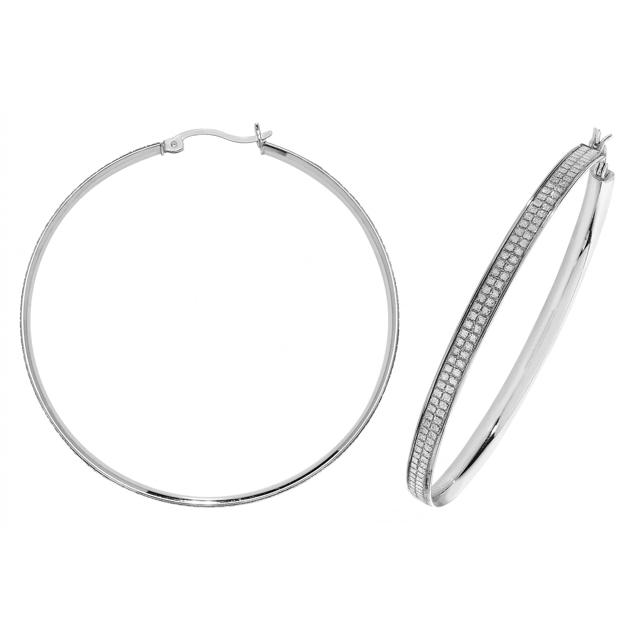 The STERLING SILVER 50MM MOONDUST HOOP EARRINGS set includes one plain hoop and one with a moondust textured edge, offering a modern take on the classic silver hoop style.