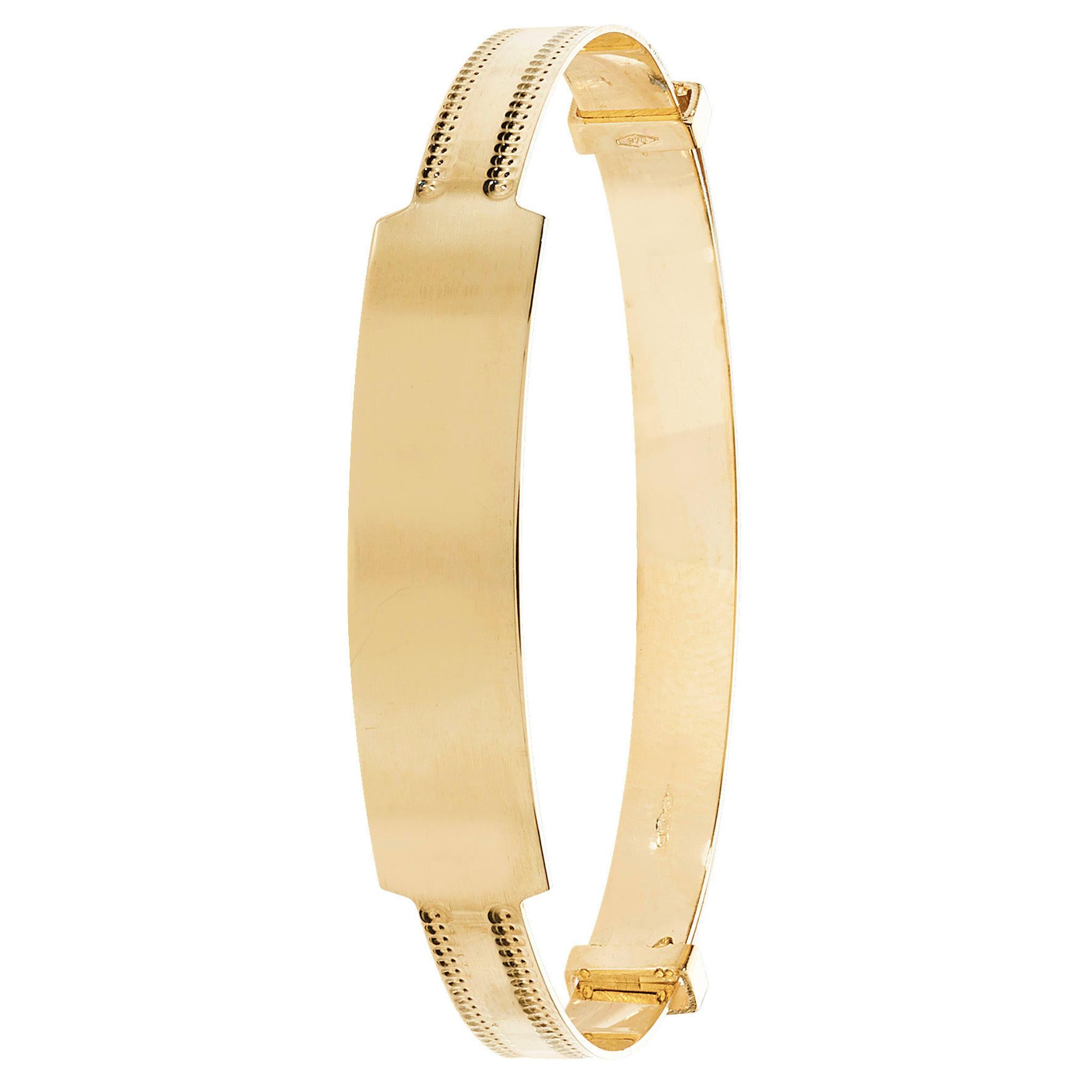 The 9CT GOLD 4MM BABY BANGLE ID MILLED EDGE features a plain, engravable central plate, a decorative milled edge, and a secure clasp closure.