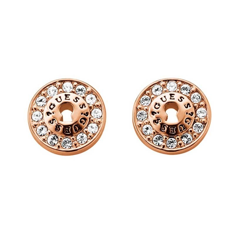 The Guess All Locked Up Rose Gold Tone Stud Earrings (UBE71331) feature a round design with "GUESS" engraving and sparkling Swarovski crystals set around the edge.