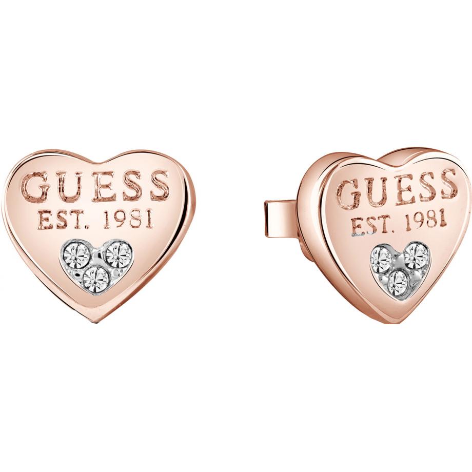 Guess Ladies All About Shine Rose Gold Plated Crystal Heart Stud Earrings (UBE82083A) feature heart-shaped studs engraved with "GUESS EST. 1981" and accented with three sparkling crystals on each earring.