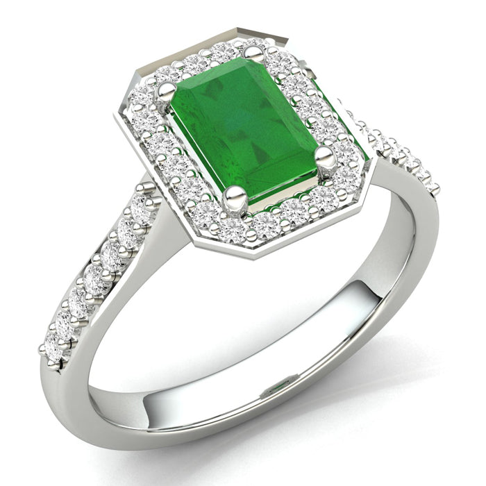 The 9ct White Gold Diamond and Emerald Cluster ring features an emerald-cut green gemstone at its center, surrounded by a halo of sparkling round diamonds on the band and around the stone.
