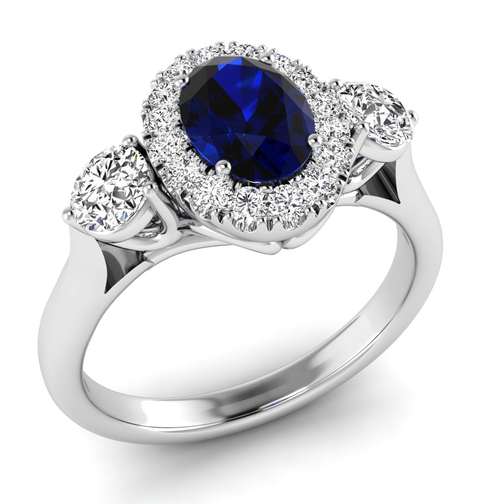 The 9ct White Gold Diamond and Sapphire Oval Cluster 0.45ct ring features an oval blue sapphire, a diamond halo, two larger side diamonds, and a polished white gold band.