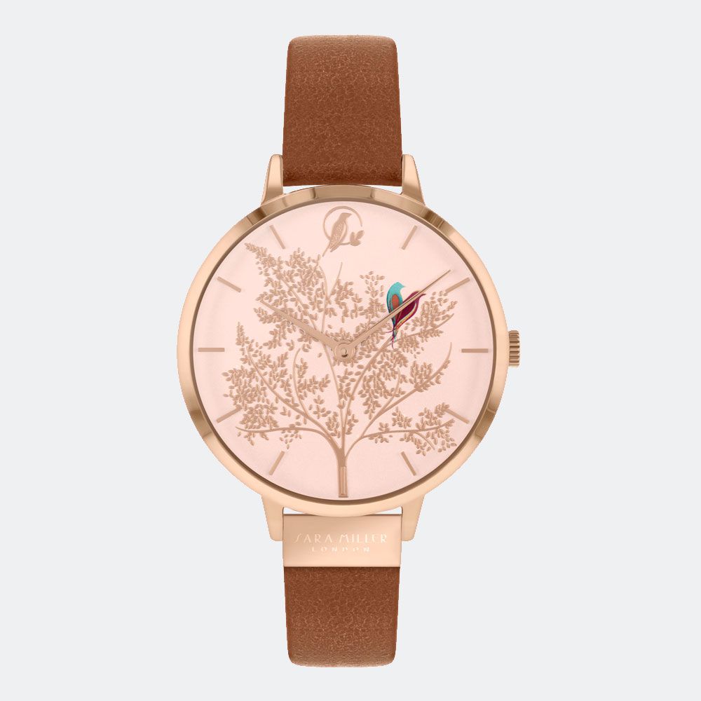 The Sara Miller Chelsea Range Love Birds Watch (SA2018) features a rose gold case, genuine leather strap, and a tree design on the dial with two birds—one perched on a branch, another near 12 o’clock—showcasing signature elegance.