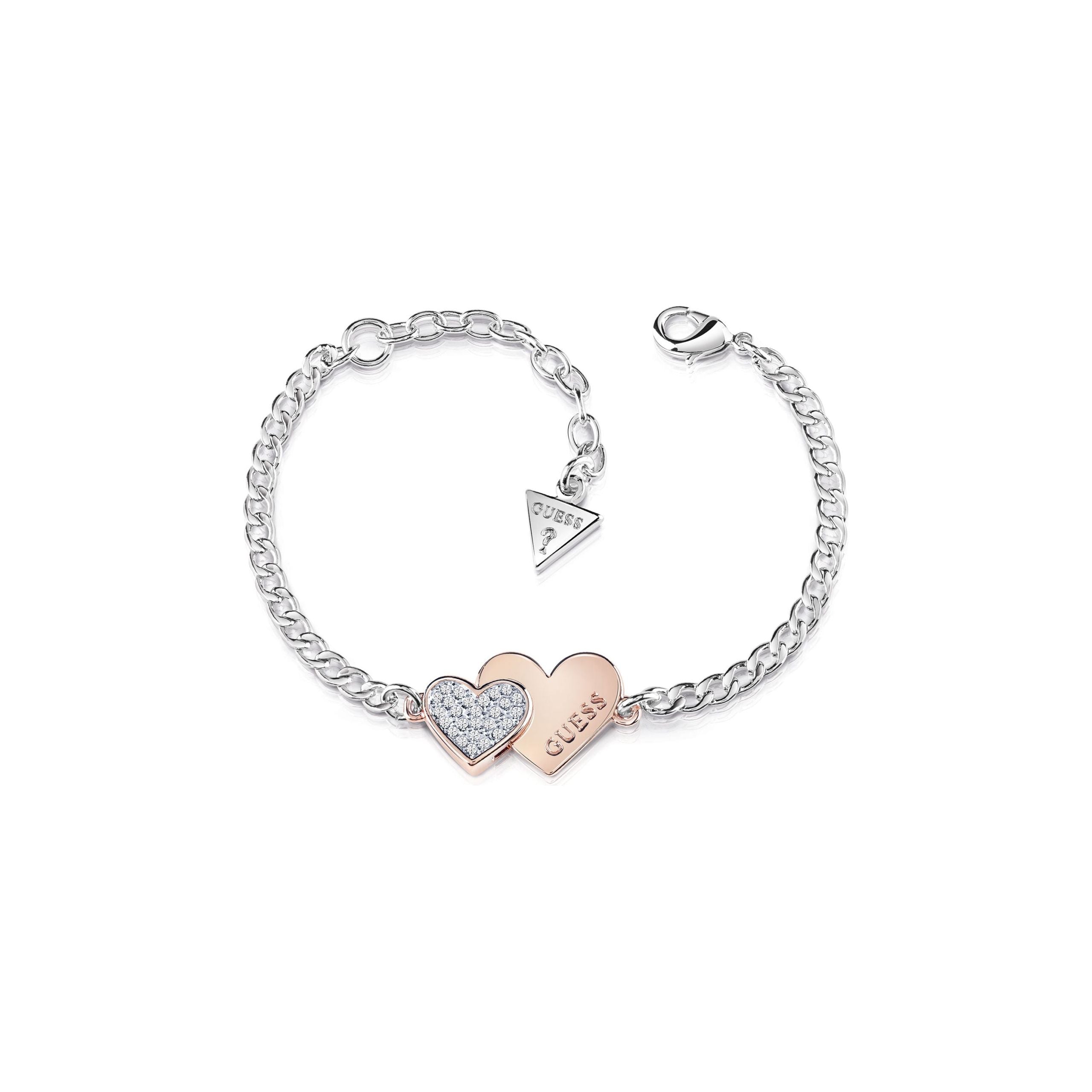 The Guess Me And You Two Tone Rose Tone Double Heart Bracelet UBB84125A-L features a silver chain, lobster clasp, two heart charms—one with Swarovski crystals, one rose gold "GUESS"—and a signature triangular GUESS tag.
