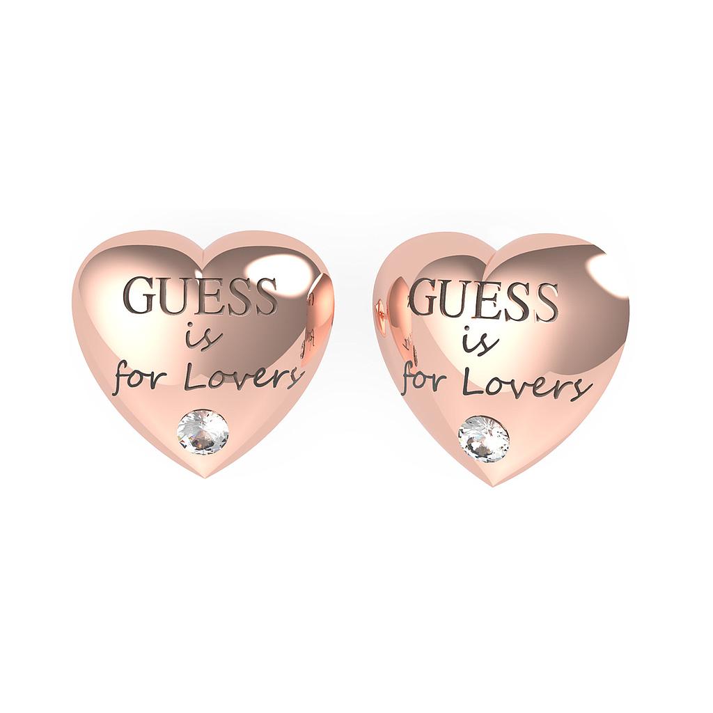 The Jewellery GUESS Is For Lovers Rose Gold Tone Heart Earrings (UBE70106) feature heart charms engraved with "GUESS is for Lovers" and a sparkling Swarovski crystal at the bottom.