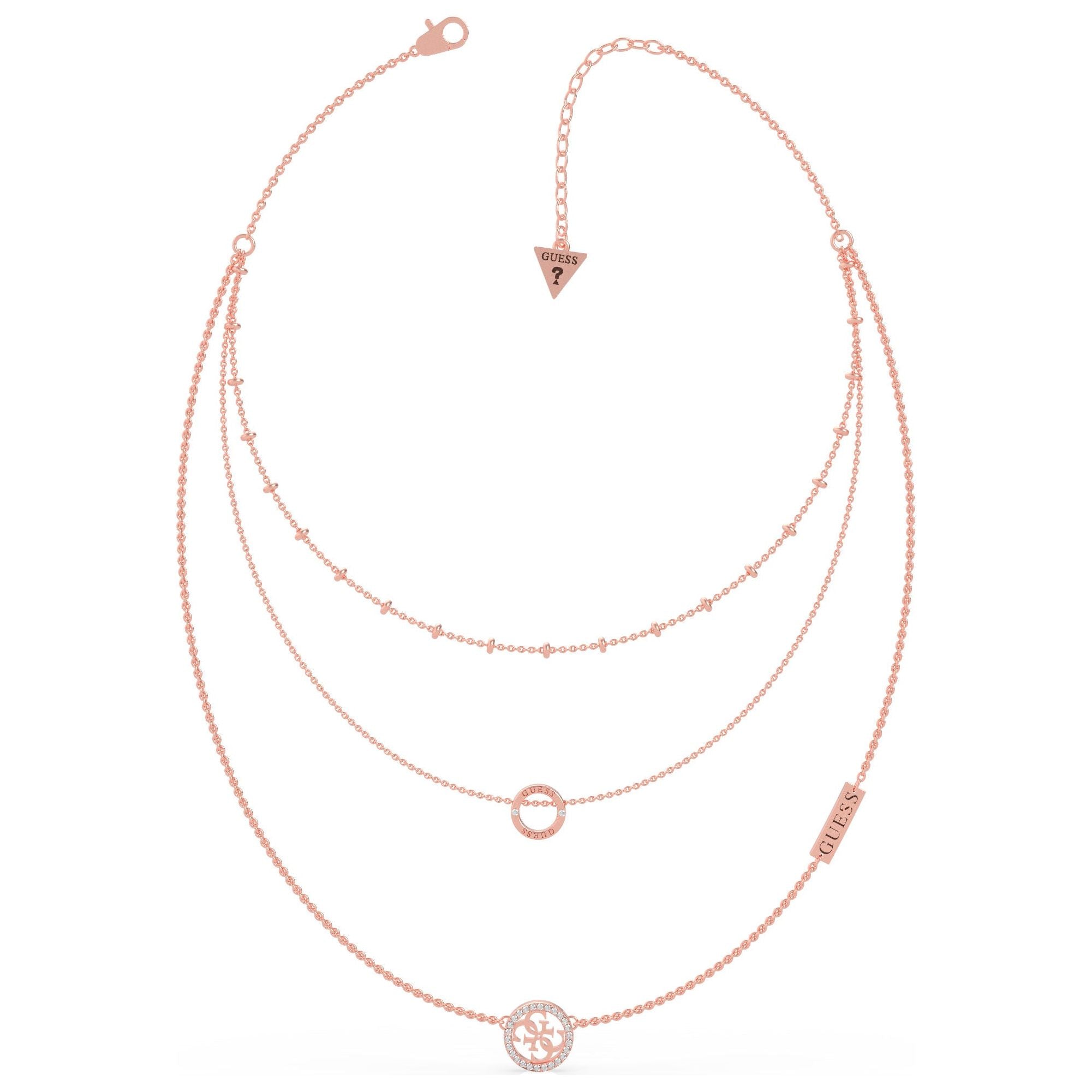 The GUESS UBN79050 Ladies Rose Gold Tone Equilibre Necklace features triple layers with small bead accents, circular and floral pendants set with Swarovski crystals, plus a "GUESS" logo charm, shown on a white background.