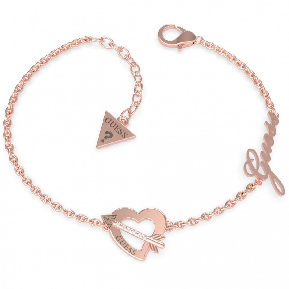 The GUESS JEWELLERY Across My Heart Rose Gold Bracelet (UBB79092-L) features a rose gold plated stainless steel band with a heart and arrow, triangular GUESS tag, and cursive "Guess" charm.