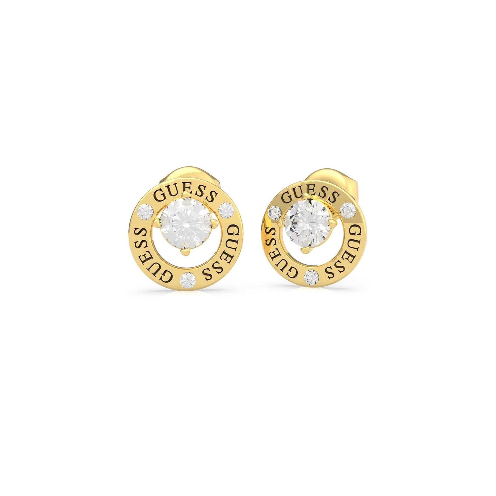 Guess Jewellery All Around You Gold Tone Crystal Set Circle Earrings (UBE20135) feature clear center gemstones, "GUESS" engraved around the border, and are accented with sparkling crystals.
