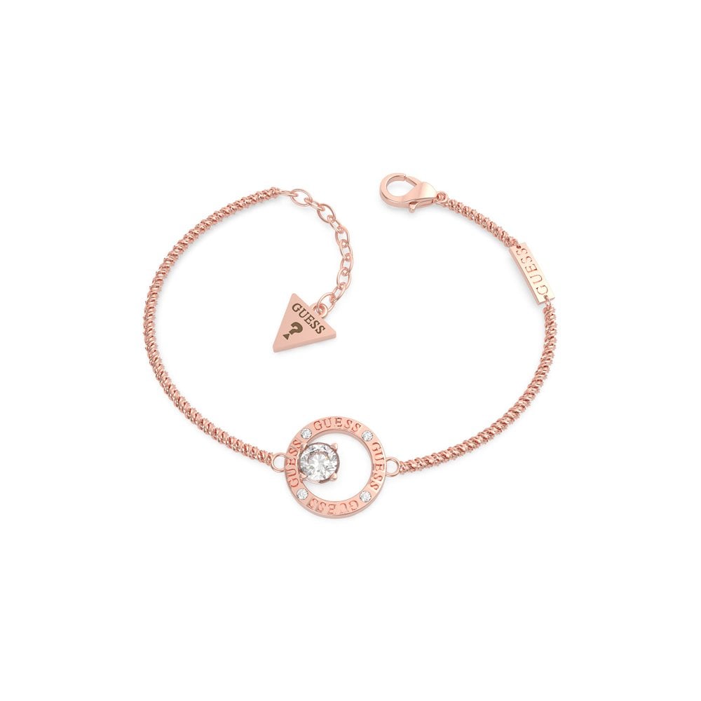 The GUESS JEWELLERY All Around You Rose Gold Tone Crystal Circle Bracelet (UBB20133-L) features a central engraved crystal circle charm and a signature triangle tag near the clasp—a standout Guess accessory.