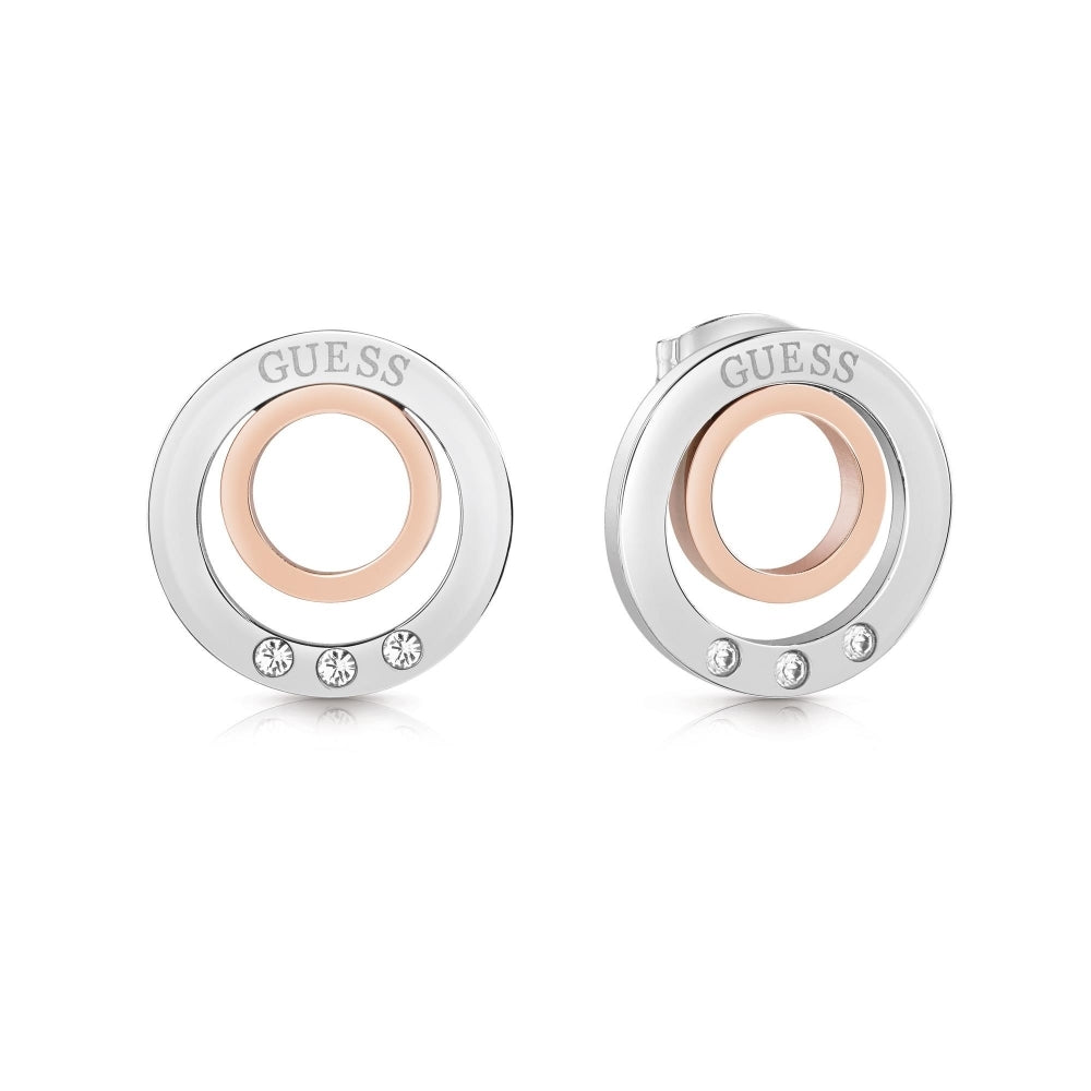 The Guess Eternal Circles Earrings UBE29029 feature circular studs in silver and rose gold tones, each adorned with three Swarovski crystals at the bottom.