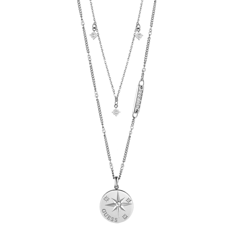 The Guess UBN20018 Wanderlust Silver Tone Crystal Set Compass and Charm Double Necklace features a compass pendant with star engraving, crystal accents, and adjustable layered chains for a stylish look.