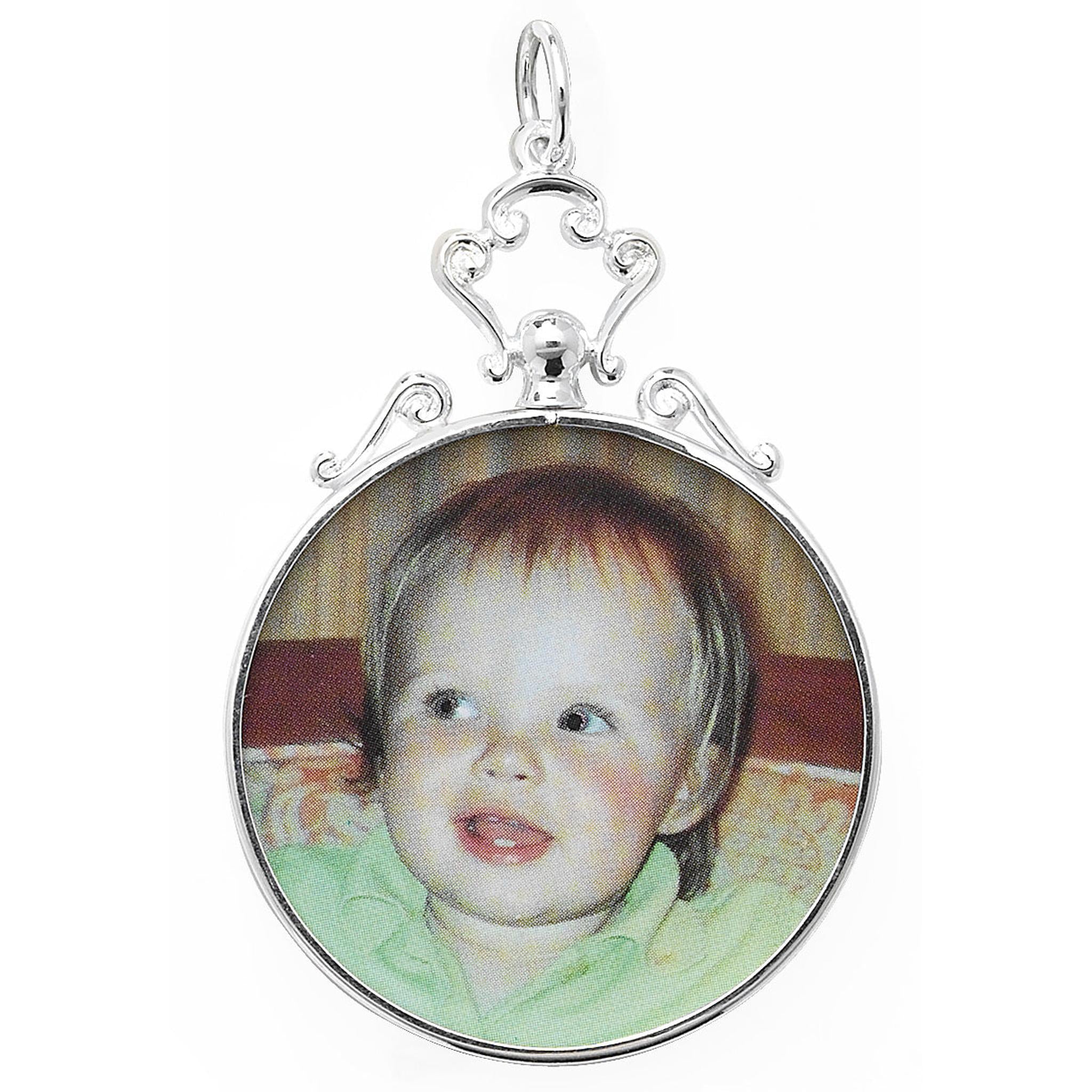 The STERLING SILVER ROUND SCROLL PICTURE FRAME PENDANT, 32mm wide and 8.3g, features a color photo of a smiling young child with light brown hair in a light green shirt.