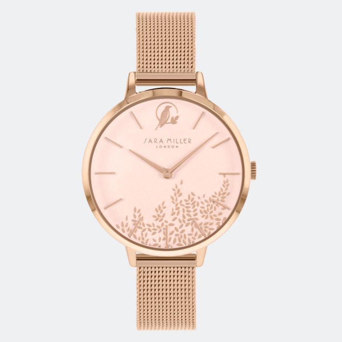 The Sara Miller Leaf Watch SA4022 features a rose gold mesh strap, minimalist markers, and a dial adorned with a floral design and gold leaf accents. The "Sara Miller London" logo is elegantly displayed on the face.