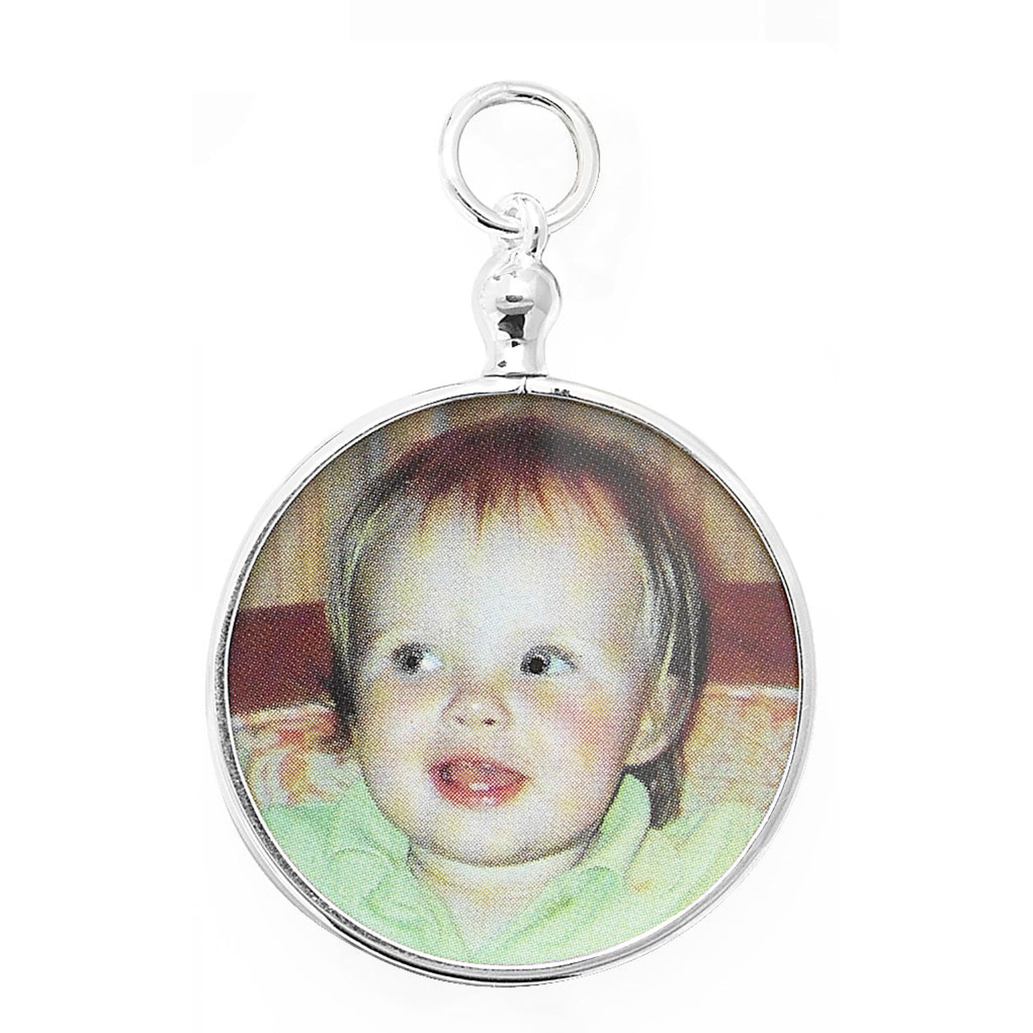 The STERLING SILVER SMALL ROUND PICTURE PENDANT is a 27mm round pendant featuring a printed photo of a smiling toddler with light skin and brown hair.