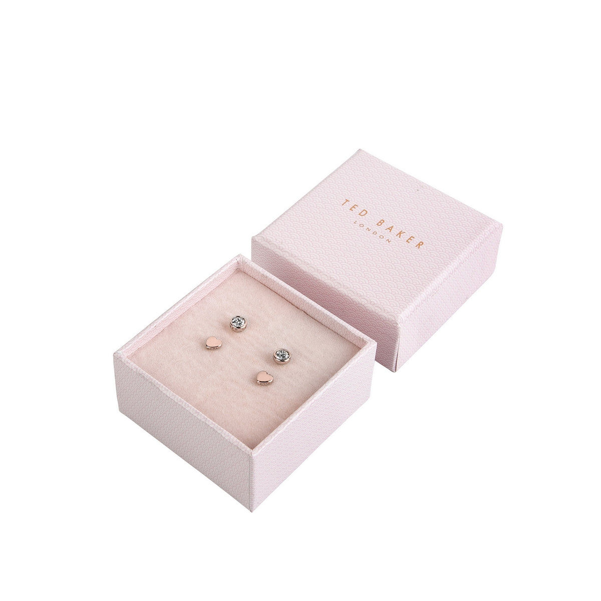 A pink TED BAKER jewelry box with the lid off displays two pairs from the Sarna Swarovski Crystal Heart Stud Earrings Gift Set (TBJ2401-24-02): one pair of clear crystal studs and one pair of delicate rose gold heart studs.