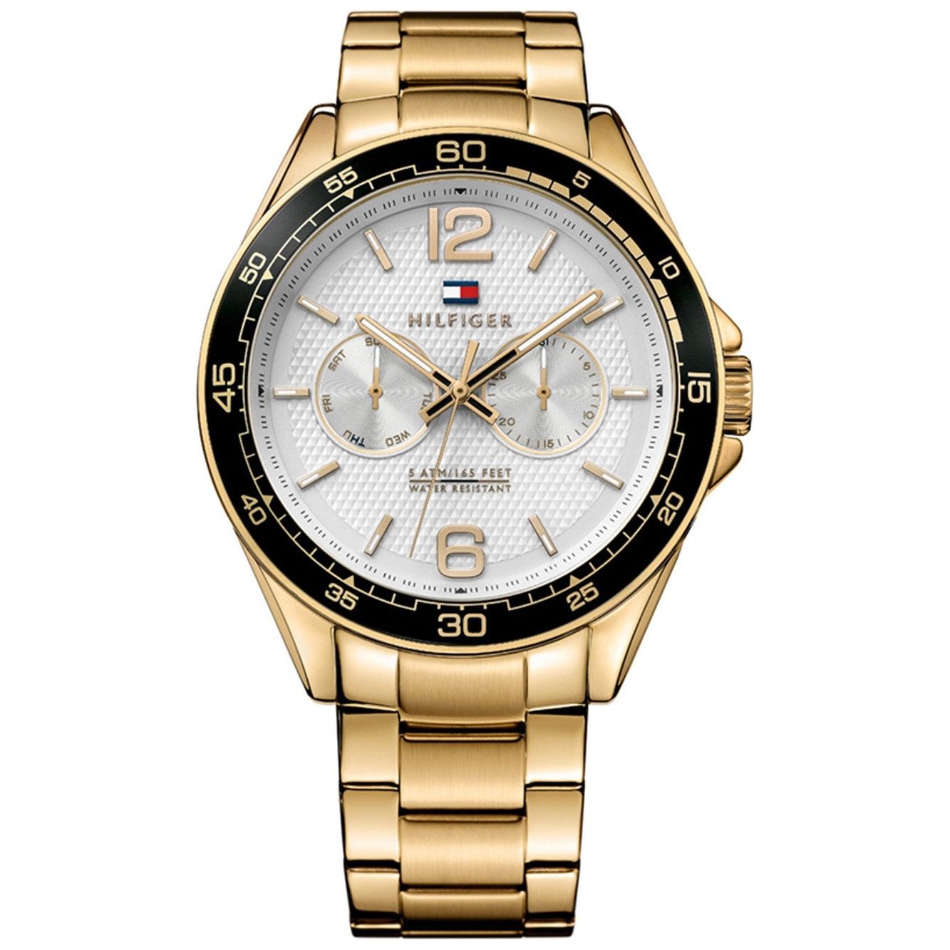 The Tommy Hilfiger Erik Gold Tone Steel Link Watch 1791365 features a gold-toned metal band, white dial, three subdials, and a black bezel with numbers in increments of five.