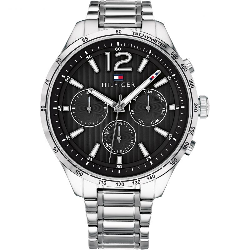 The Tommy Hilfiger Gavin Men's Black Chronograph Watch 1791469 features a silver case, black dial, three subdials, date and day indicators, and a tachymeter bezel.