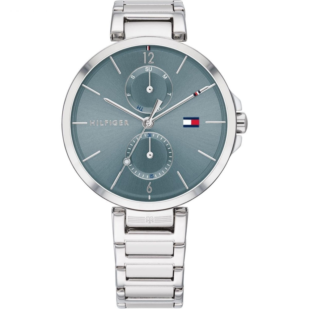 The Tommy Hilfiger Ladies Angela Stainless Steel Bracelet Watch 1782126 features a stylish silver design with a blue day-date dial, two subdials, silver hour markers, and the iconic Hilfiger flag logo.