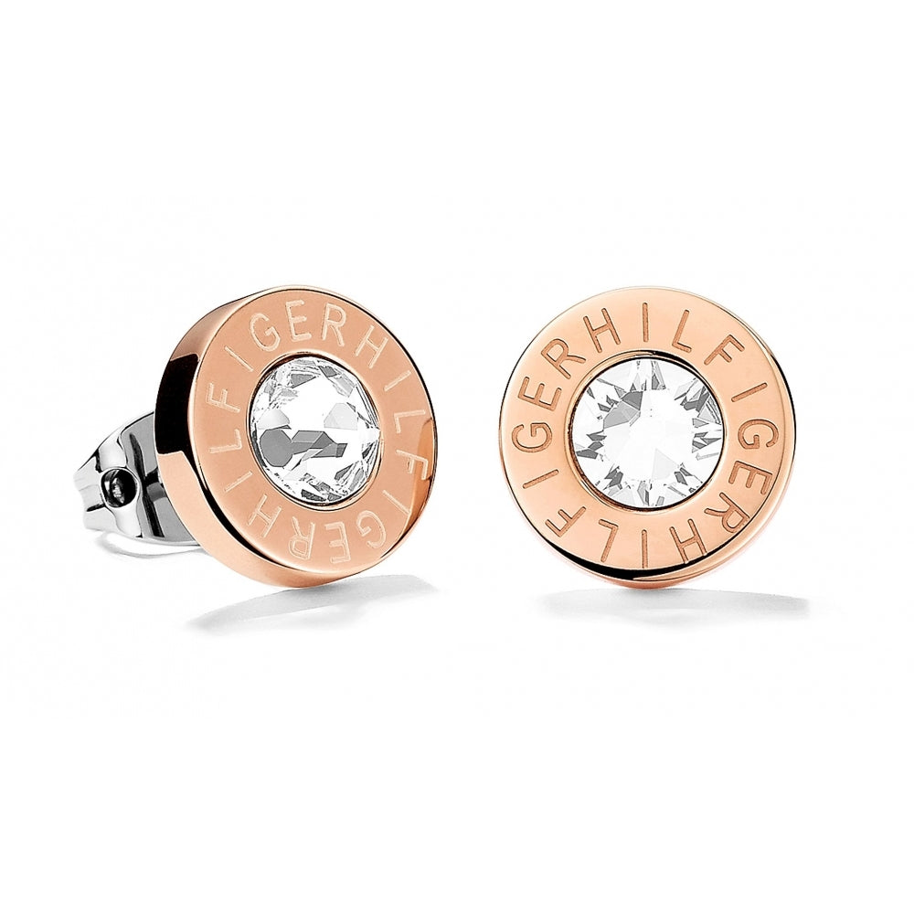 A pair of Tommy Hilfiger Rose Gold Tone Clear Crystal Round Logo Stud Earrings (2700752) featuring a central clear crystal and "HILFIGER" engraved around the edge.