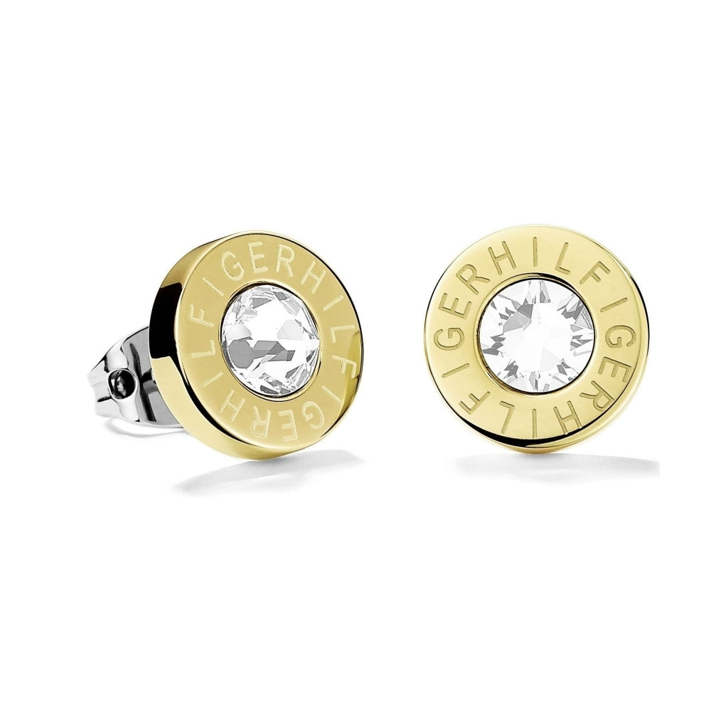 These Tommy Hilfiger Gold Tone Crystal Round Logo Studs (2700753) feature clear central crystals, gold-tone round edges, and "HILFIGER" engraved around each stone.