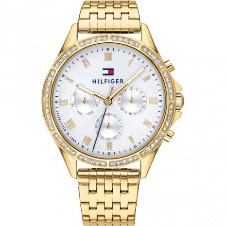 The Tommy Hilfiger Ladies Ari Quartz Watch (1782142) features a gold stainless steel strap, white face, crystal-studded bezel, three subdials, and the brand logo at the top center.